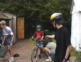 James attempts saddle adjustments to Lee's bike outside Quantock Hills youth hostel